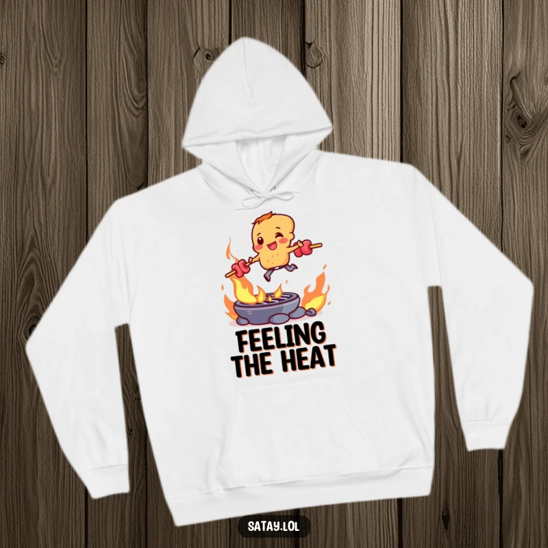 Funny satay skewer character bravely jumping over a flaming grill, featured on a warm and cozy hoodie.
