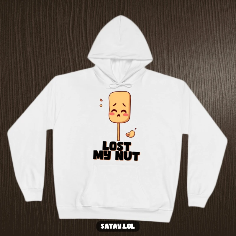 Funny hoodie with a satay skewer character looking comically confused, a misplaced peanut nearby; cozy and humorous.