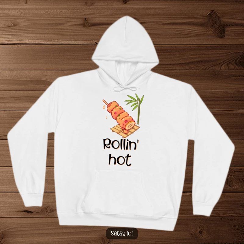 Funny satay skewer hoodie, showing a skewer rolling with gusto down a bamboo mat, a warm and humorous apparel piece.